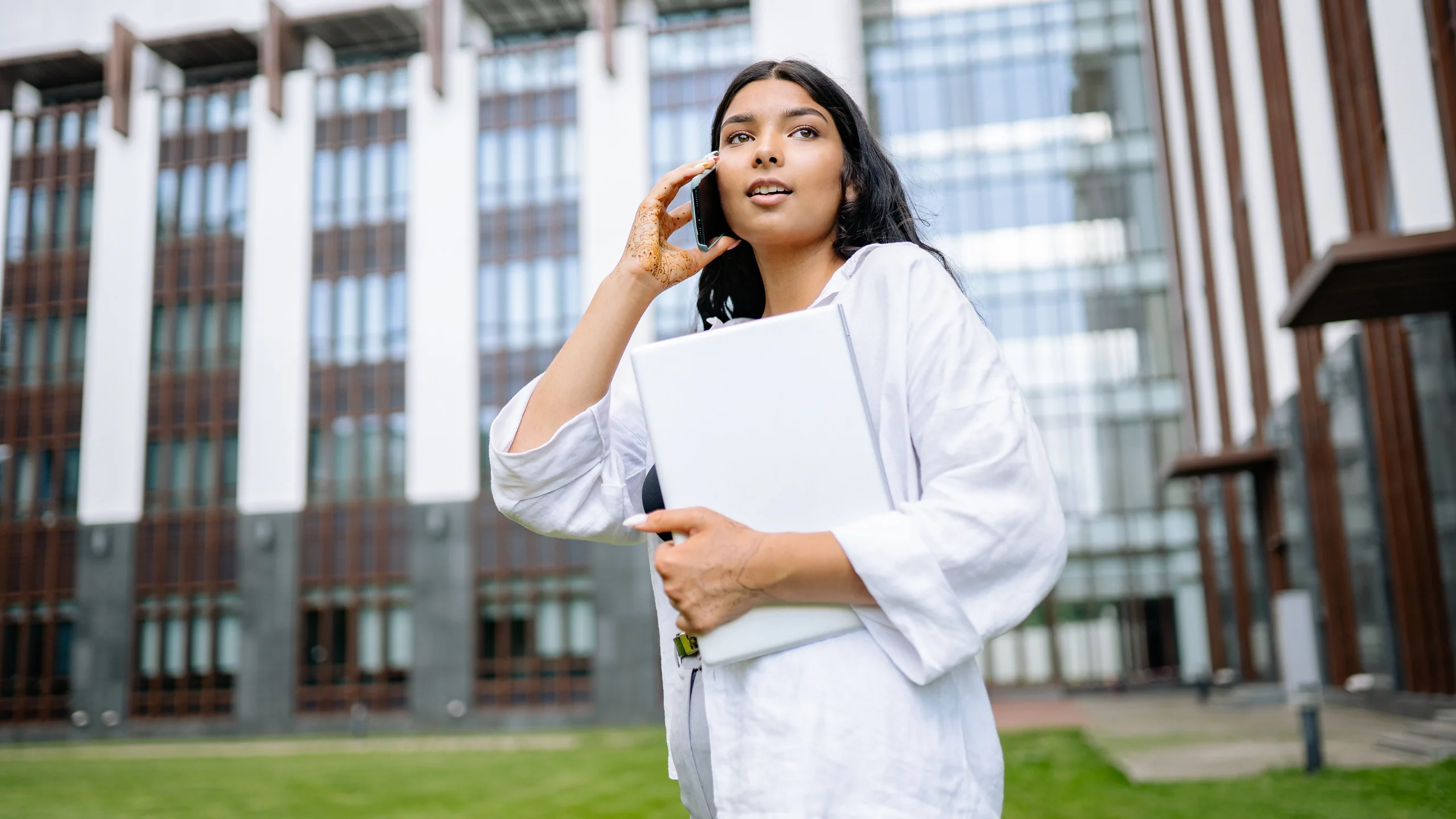 Professionista al telefono davanti a un edificio contemporaneo